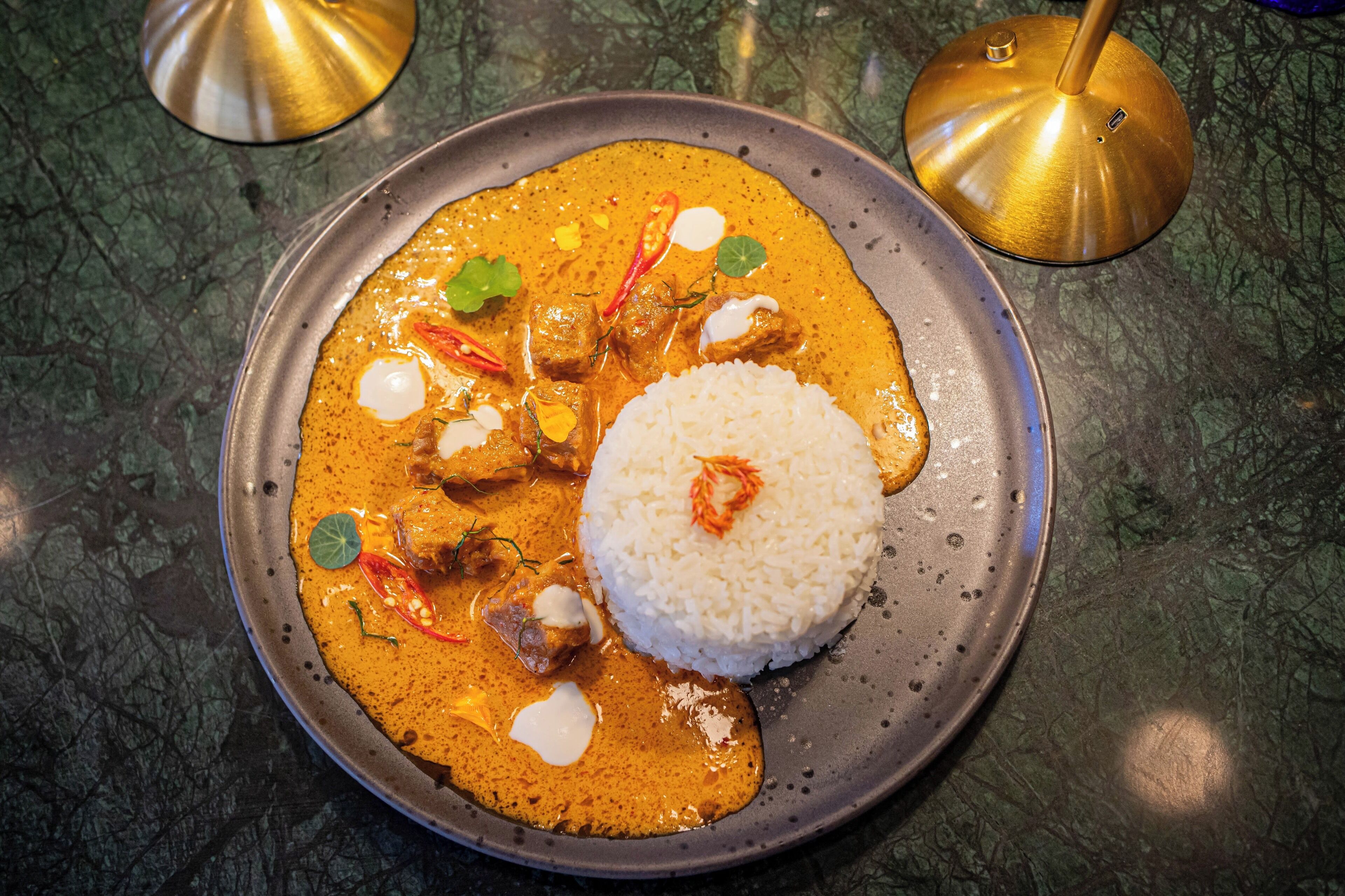 Un plato de curry con arroz sobre un plato de metal.