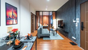 Een moderne hotelkamer met een zithoek, een bank, een televisie en een groot stadsgezicht schilderij.