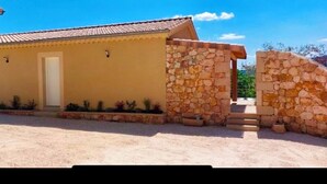 A building with a yellow facade and a stone entrance. - The Montchamp villa (Chambonas)