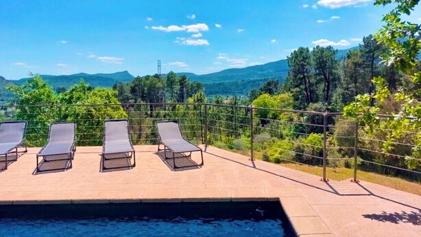 A poolside area with lounge chairs and a view of mountains. - The Montchamp villa (Chambonas)