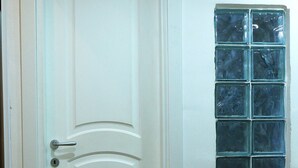 A white door with a keyhole and a handle, a window with blue glass panes, and a wicker basket on the floor. - Perfect for exploring Naples without having to use transportation.  (Napoli)