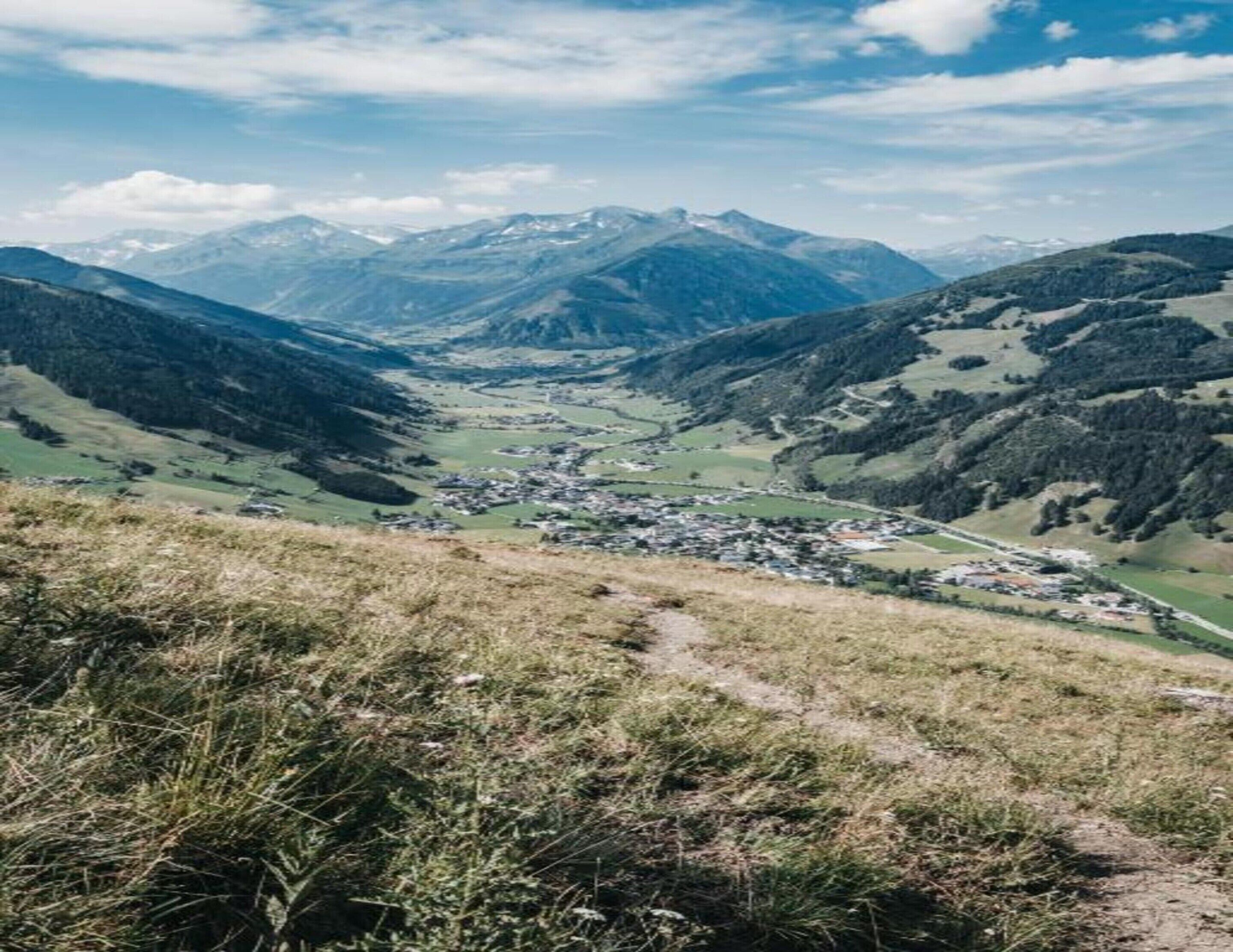 A mountainous landscape with a valley and a small town.