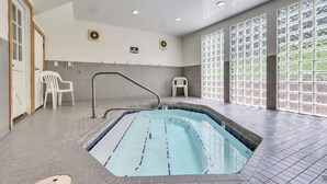 Piscina con solárium de baldosas, un cartel de prohibido fumar y vistas a través de amplias ventanas.