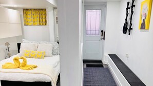 A modern hotel room with a bed, a bench, a shower, and a door. - Stylish 1 Bedroom Apartment close to Bloor West Village (Toronto)