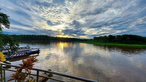 Un río con barcos, barandas y follaje.