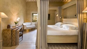 A bedroom with a large bed, a desk with a lamp, and a chair. - Villa Olimpia in Sarteano (Sarteano)