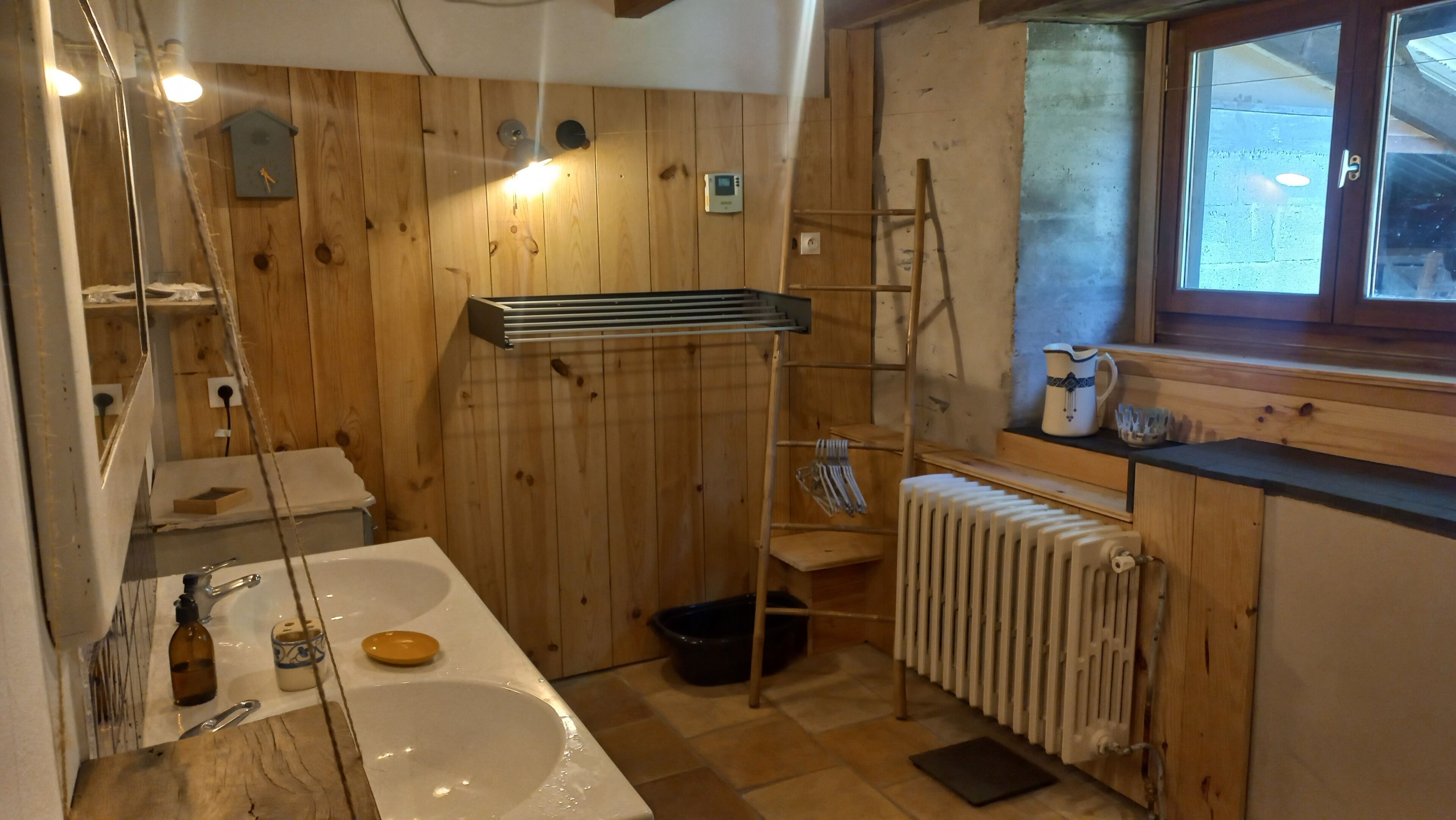 Un interior de madera con un lavabo, espejo y radiador.