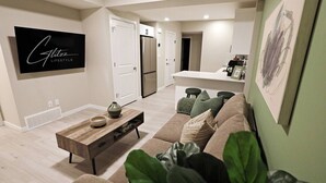Un salon moderne avec un canapé, une table basse et un téléviseur à écran plat.