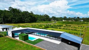 Ein modernes Gebäude mit Schwimmbad, großen Glasfenstern und einer flachen Dachfläche.