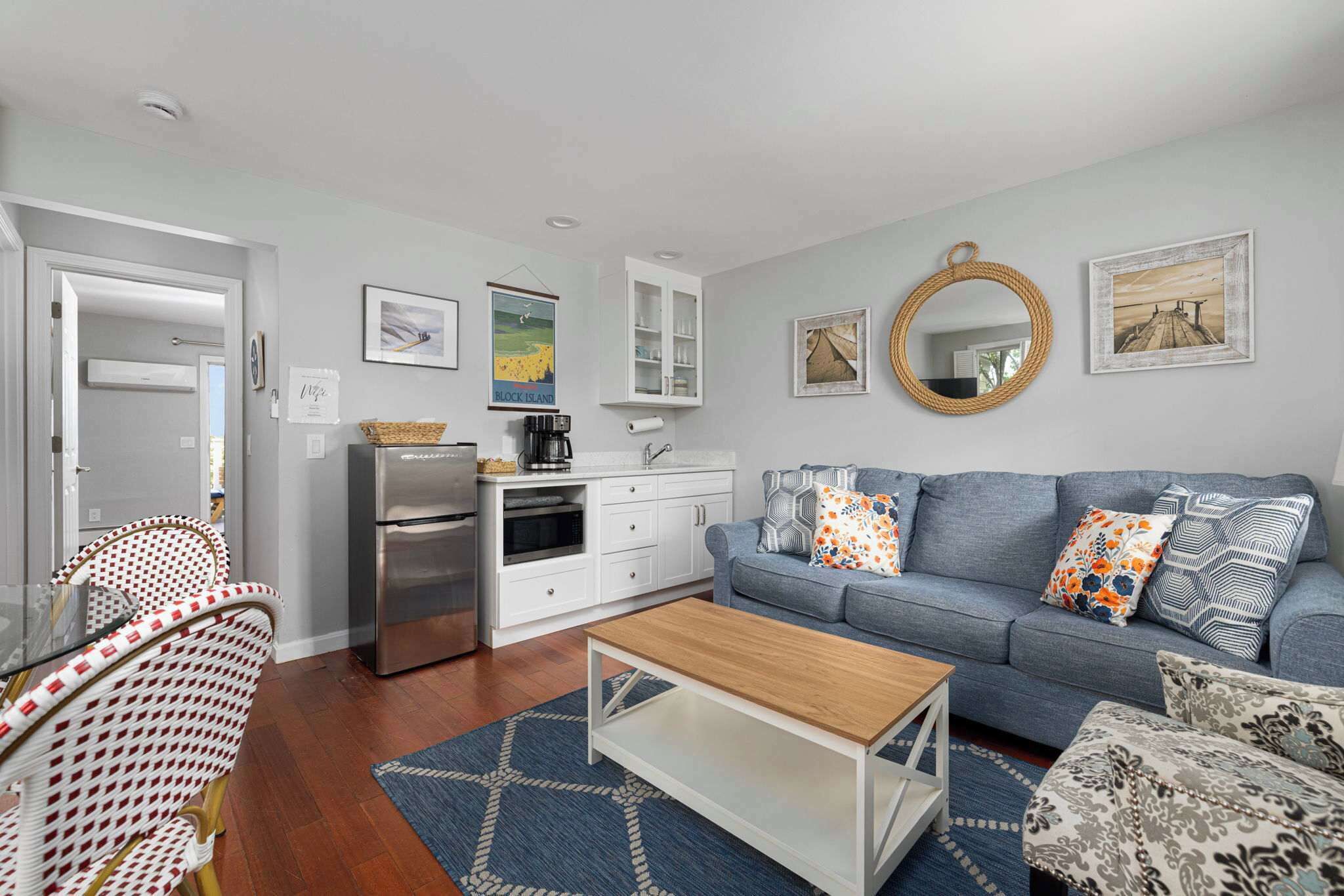 A compact living space with a kitchenette, a sofa set, and a dining area.