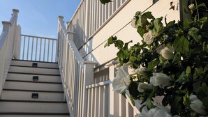 A staircase with white railings and a white building in the background. - Waverly Suite 3 (New Shoreham)