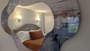 A bedroom with a bed, two wall-mounted lamps, and a door. - Waverly Suite 3 (New Shoreham)