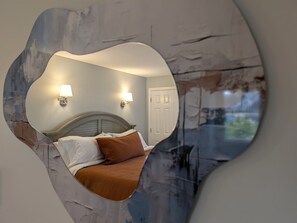 A bedroom with a bed, two wall-mounted lamps, and a door. - Waverly Suite 3 (New Shoreham)