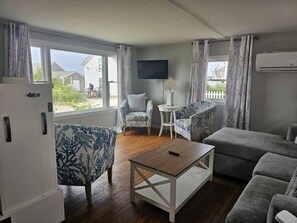 A living room with a sofa, armchairs, a coffee table, and a TV. - Sherman Cottage (New Shoreham)