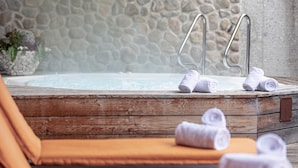A hot tub with metal steps, surrounded by a stone wall. - Ferienwohnung mit 2 Schlafzimmern fur 5 Personen (Reith bei Kitzbuehel)