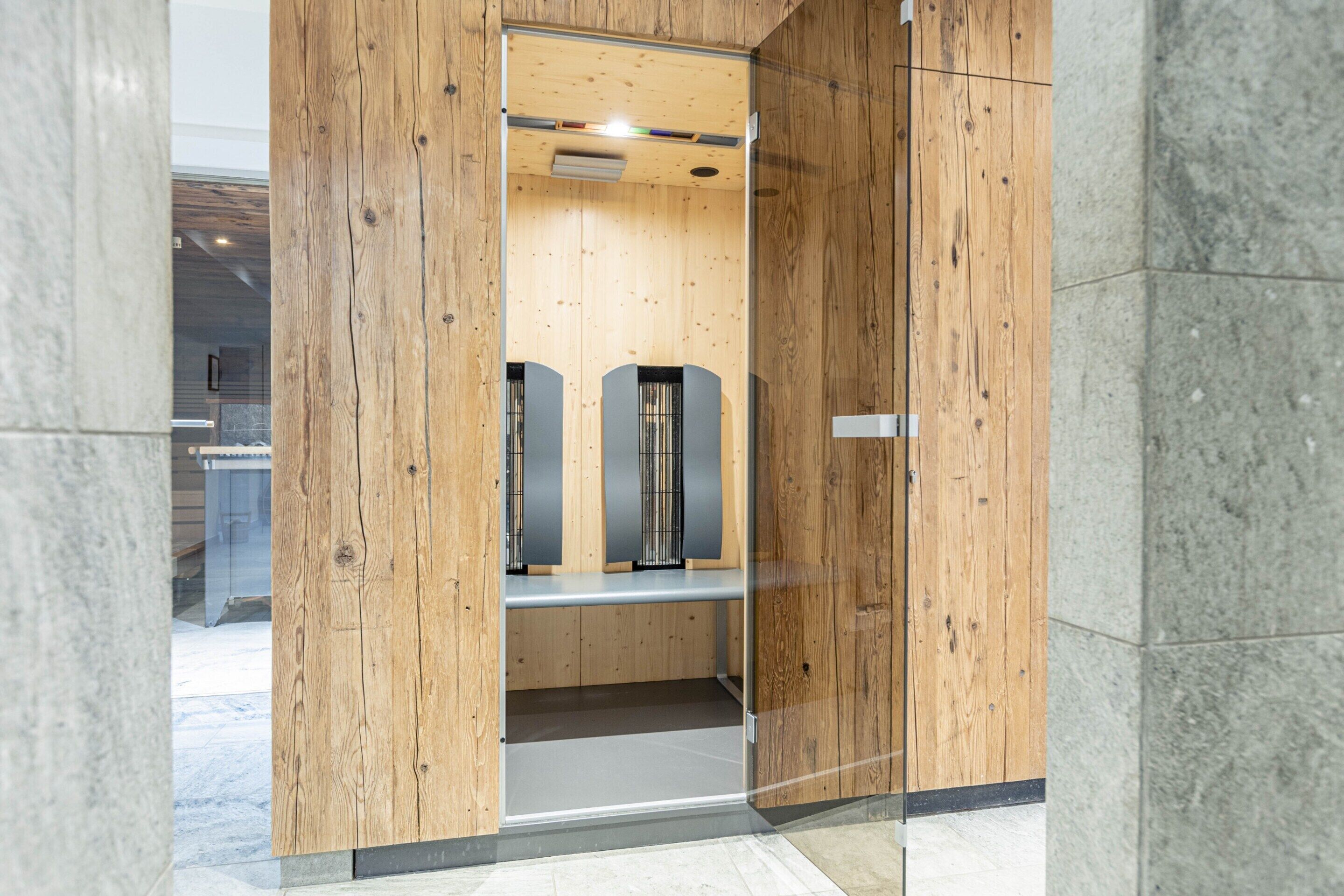 Een moderne lift met houten lambrisering en een metalen interieur.