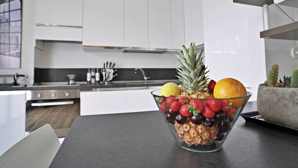 Una cucina moderna con mobili bianchi ed elettrodomestici in acciaio inossidabile.