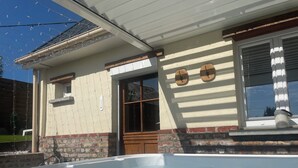 Um edifício residencial com piscina, base de tijolos e porta de madeira.