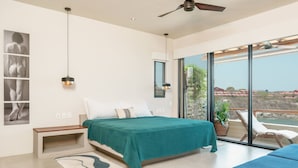 Une chambre moderne avec un grand lit, une vue sur l’extérieur et un ventilateur de plafond.