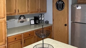 A kitchen with wooden cabinets, a coffee station, a pantry sign, and a refrigerator. - Quite, private 4 bed room 2 full bath home located in Newark oh. Sleeps 12. (Heath)