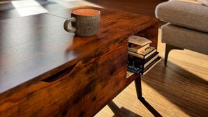 A cozy cabin interior with a wooden table, a mug, and books.