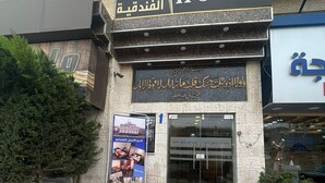 The exterior of the Msaya Al Diar Hotel with a signboard in Arabic and English, a staircase leading to the entrance, and a poster advertising the hotel. - Masaya Aldiar (Amman)