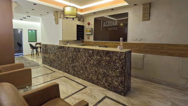 A hotel reception area with a marble counter, seating, and a sign reading "MALDAR HOTEL". - Masaya Aldiar (Amman)