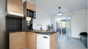 Eine moderne Küche mit Holzausstattung, einer eingebauten Mikrowelle und einem Geschirrspüler.