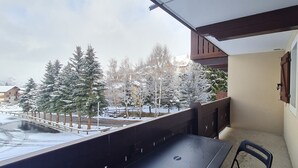 Un balcón con vistas a árboles nevados y edificios.