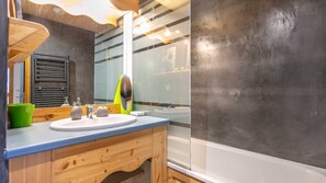 A modern bathroom with a wooden vanity, a large mirror, and a bathtub. - Flat at the foot of the slopes with a balcony (Modane)