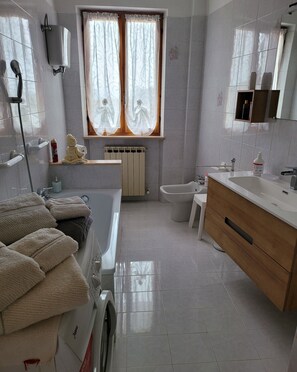Een haardroger, handdoeken, zeep, toiletpapier