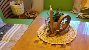 Una mesa de madera con un cajón para un tablero de ajedrez, una vela y un adorno.
