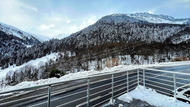 A road with metal guardrails, surrounded by snow-covered trees and mountains. - Maison Auseths - Group accommodation - Campan (Campan)