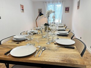 Una mesa de comedor dispuesta para una comida, con platos blancos, vasos y cubiertos.