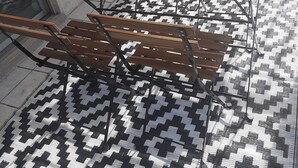 Una mesa de madera y bancos con un tapete blanco y negro.