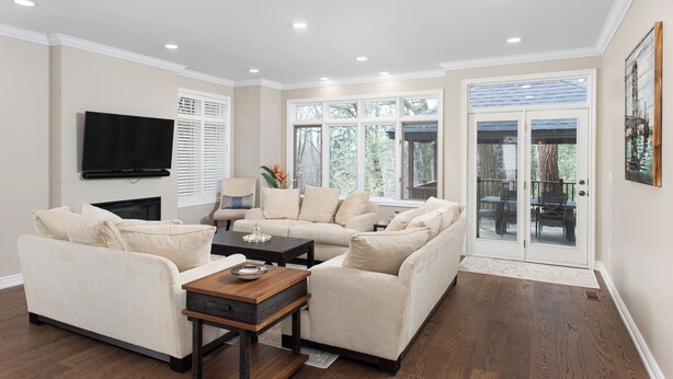 A spacious living room with a beige sofa set, a coffee table, and a flat-screen TV mounted on the wall. - Spacious & Modern Home in The Heart of Toronto (Toronto)