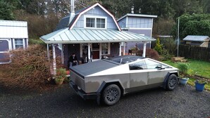 Une maison moderne au design original, dotée d’un porche abrité et d’une allée gravillonnée.