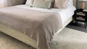 A bedroom with a bed, bedside tables, and a nightstand.
