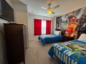A bedroom with two beds, a ceiling fan, a TV, and a mural on the wall. - 4 Bedroom 3 Bathroom Villas At Seven Dwarfs 28-107 (Kissimmee)