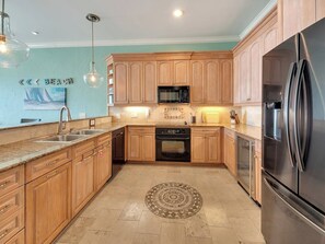 A kitchen with wooden cabinets, a stainless steel refrigerator, a microwave, and a dishwasher.