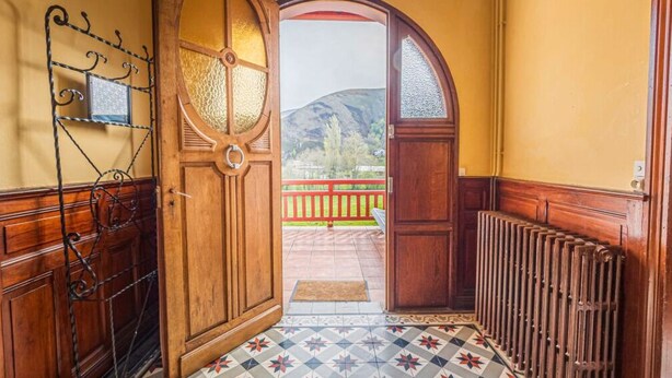 A wooden door with a glass panel, a metal rack, and a radiator. - Charming cottage (Aldudes)