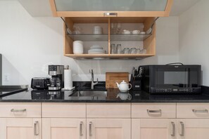 Kylskåp, mikrovågsugn, kaffe- och tebryggare och grytor/köksredskap