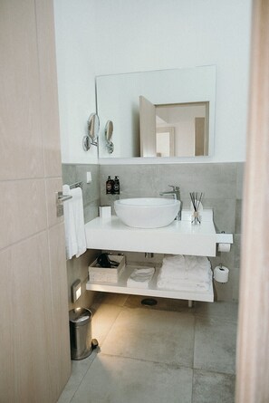 A modern bathroom with a white sink, mirror, and towel rack. - Elevem Boliqueime (Loulé)