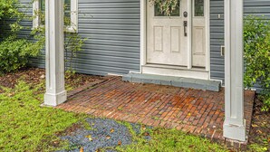 A house with a white front door, a number '65' above it, and a brick pathway leading to the entrance. - The McCaskill Cottage in the Village of Pinehurst!  (Pinehurst)