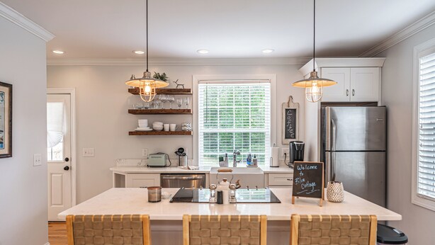 A modern kitchen with a central island, pendant lighting, and built-in cabinetry. - The McCaskill Cottage in the Village of Pinehurst!  (Pinehurst)