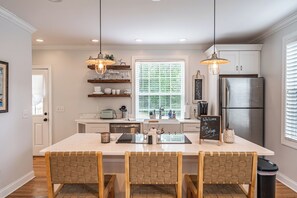 A modern kitchen with a central island, pendant lighting, and built-in cabinetry. - The McCaskill Cottage in the Village of Pinehurst!  (Pinehurst)