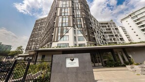 A modern multi-story building with a prominent entrance and a sign indicating it is a house. - Loxwood Apartment (Accra)