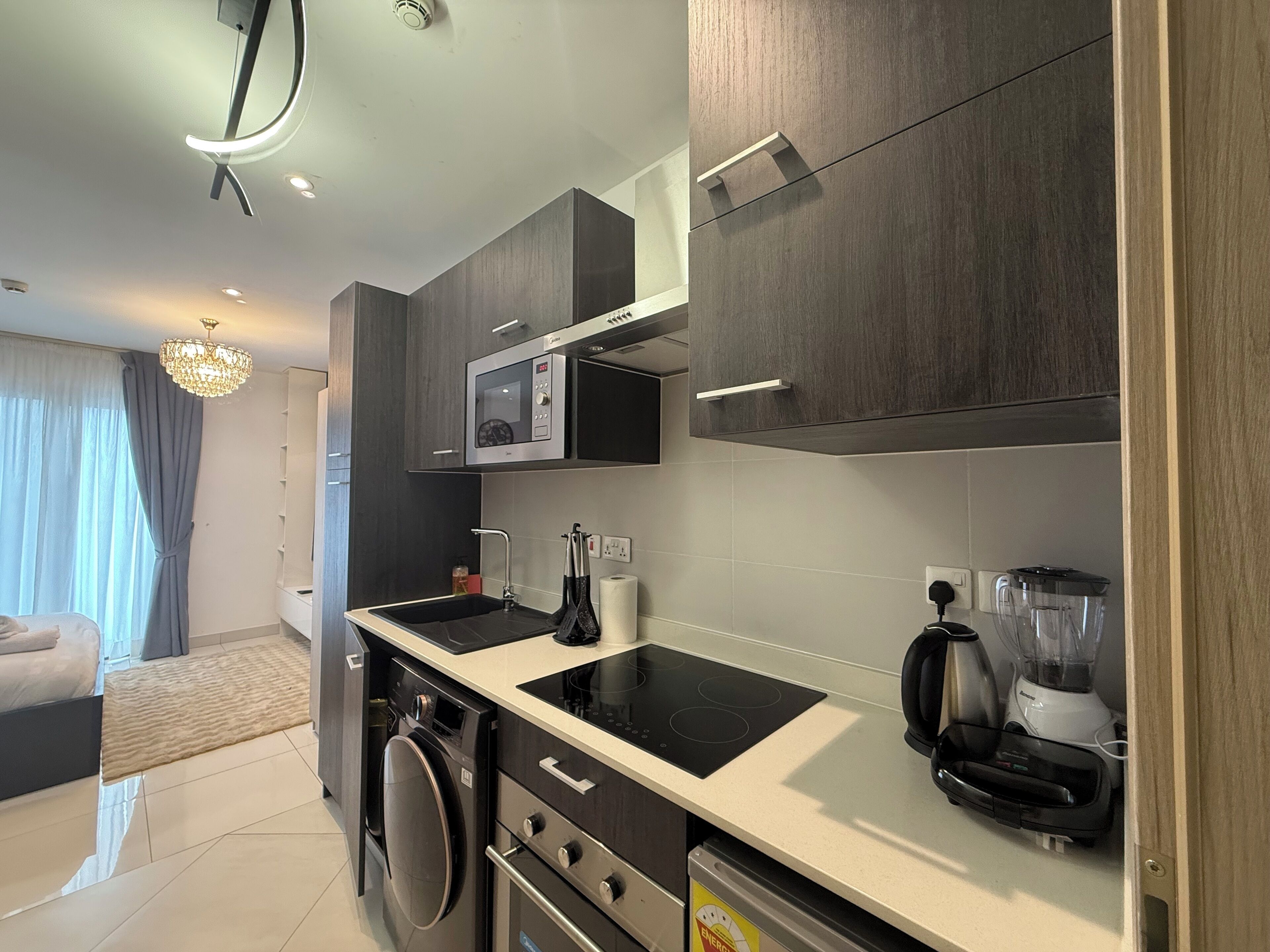 A modern kitchen with a built-in microwave, a coffee maker, and a dishwasher.