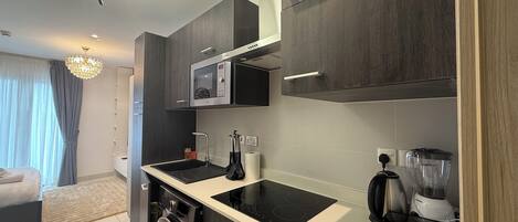 A modern kitchen with a built-in microwave, a coffee maker, and a dishwasher.
