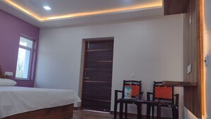 Une chambre à coucher avec un lit, une porte en bois et une petite table avec des chaises.